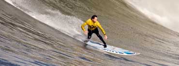 A Surfer Rides Down A Wave Cover Photo